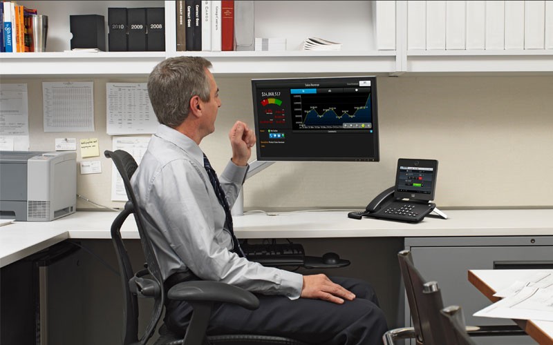 Business man monitoring laptop and desktop device