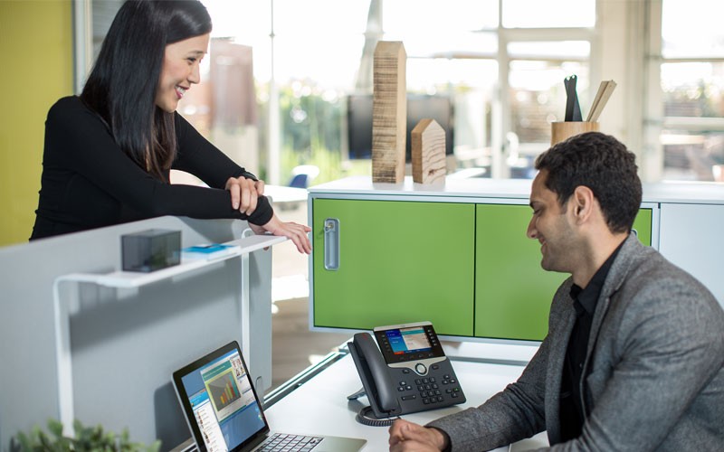 Employee visiting another employee at benching workstation