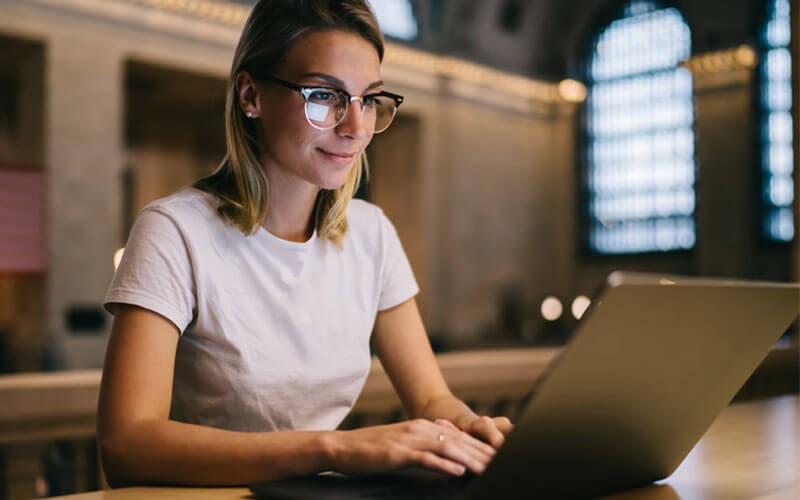 Woman smiling while using laptop