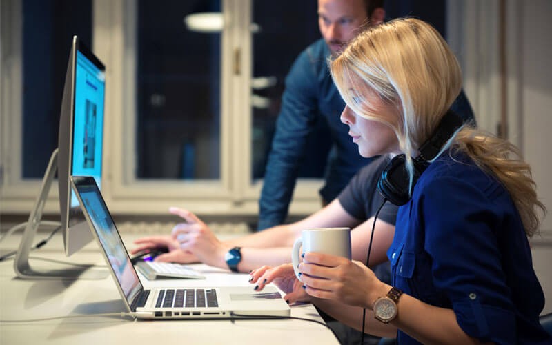 Woman working at open desk with laptop
