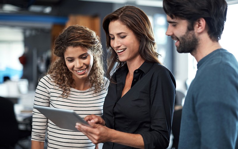 Two business colleagues use mobile tablet device 